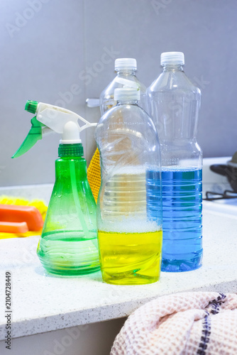 Foto Various cleaning products and detergents in reusable plastic bottles on a kitche