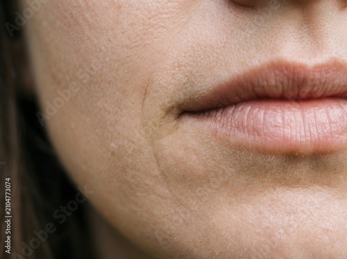 Macro Close-Up of a Woman's Closed Lips and Natural Skin Texture, Showing Fine Pores and a Single Tear Trail Running Down the Cheek, Dermatology and Beauty Detail Concept