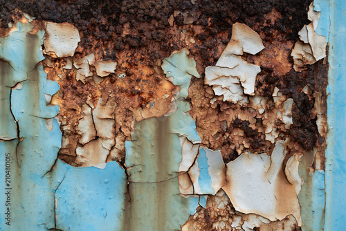 Blue peeling paint and heavy rust texture on weathered industrial metal