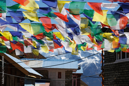 Tableau sur toile Colorful Tibetan prayer flags hanging over traditional lodges in Yak Kharka vill