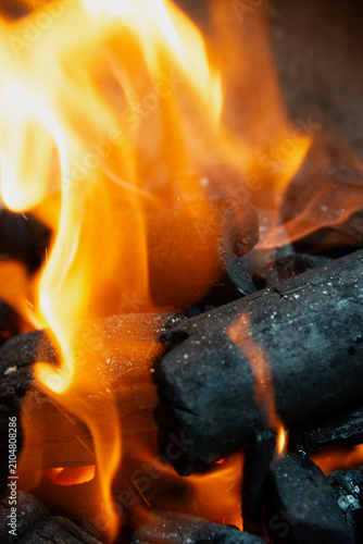Obraz na plátně Charcoal briquettes burning with orange and yellow flames, creating heat for out