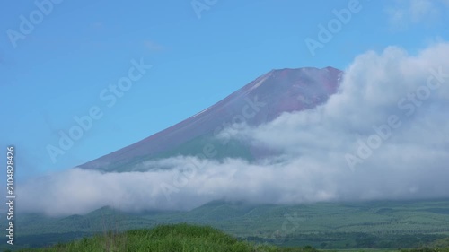 山開きを迎えた夏の富士山、早朝の空を流れる雲と登山シーズンの雄大な自然風景