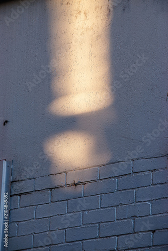 sunlight reflected on painted brickwall and cement