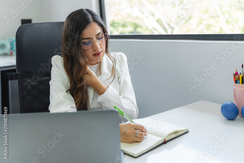 Fotografía Business professional concentrating while writing in office notebook