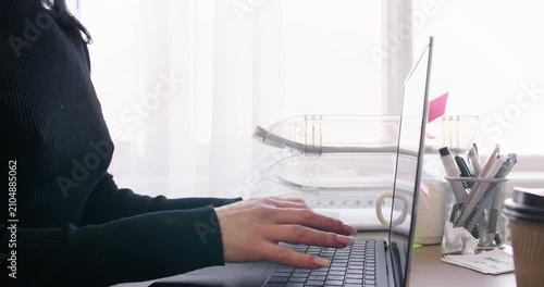 Female manager. Internet freelance. Unrecognizable entrepreneur working at desk typing on laptop at workplace for professional occupation.