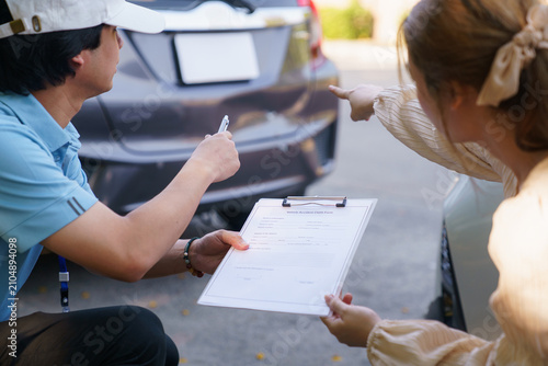 Insurance agent discussing accident report document with female driver