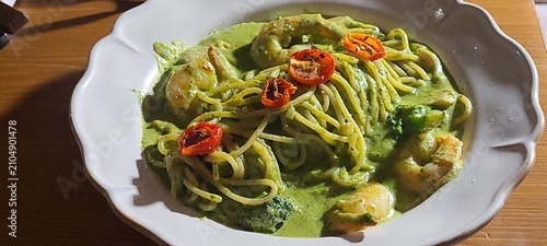 Basil spaghetti made with al dente pasta tossed in fragrant basil sauce, blended with olive oil and garlic, creating a simple yet flavorful dish with fresh green color and aromatic taste