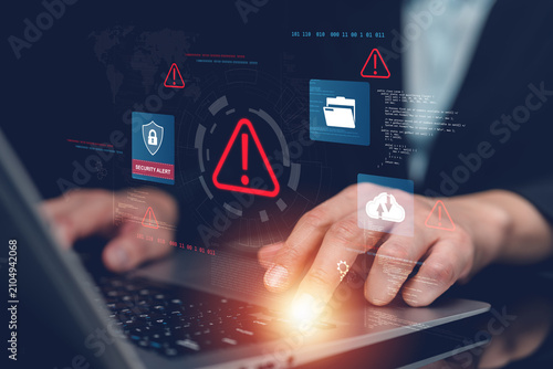 Businessman monitoring cybersecurity alerts on laptop with virtual security interface, threat detection, data protection, cloud security, cyber risk management, malware prevention and network defense