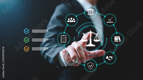 Businessman touching a digital legal compliance interface with justice scale icon, governance, contract management, audit, policy, regulation, risk management, corporate law and legal technology.