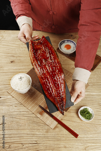 Whole Grilled Eel Served with Rice and Side Dishes on Wooden Table