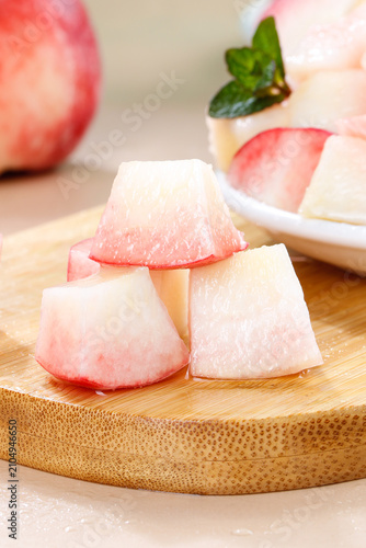 Fresh sliced white peach on wooden board