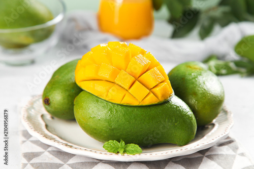 Fresh Vietnamese Green Mangoes with Golden Flesh on White Plate