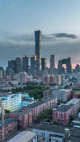 A time-lapse panorama of the Beijing CBD architectural complex, transitioning from night to day.