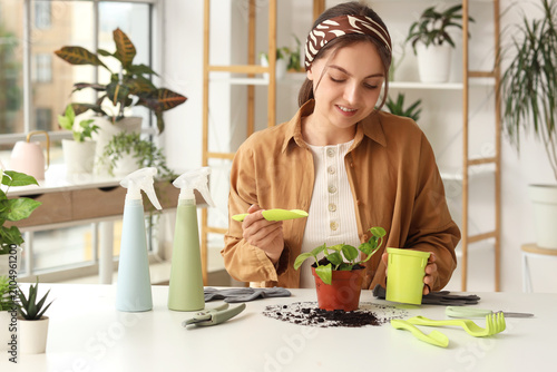 Young woman repotting a sma...
