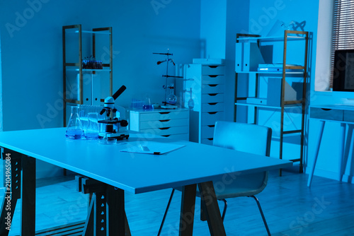 Modern laboratory interior with microscope beakers and scientific equipment o...