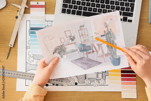 Female interior designers hands with drawing at table, top view