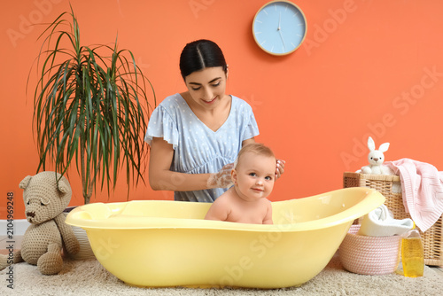 Happy mother bathing her ba...