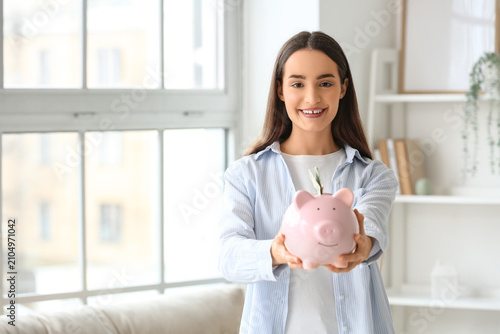 Young woman holding piggy b...