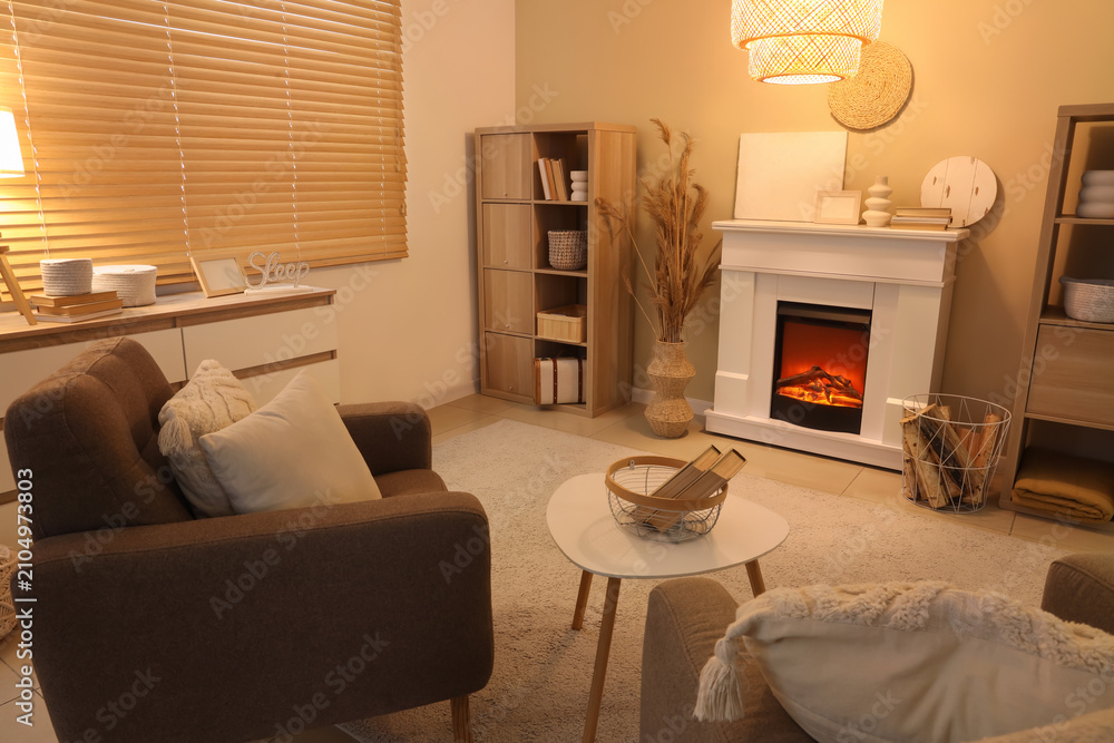 Obraz premium Interior of cozy living room with fireplace, armchairs and coffee table