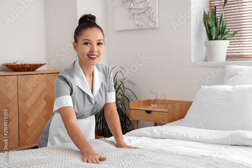Pretty chambermaid making b...
