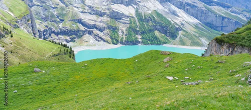 Panel kuchenny z motywem Scenic landscape of Oeschinensee or turquoise Oeschinen Lake in summer under blue sky with wildflowers and Stunning Swiss Alps. Spectacular green meadow hiking trail view, Kandersteg, Switzerland