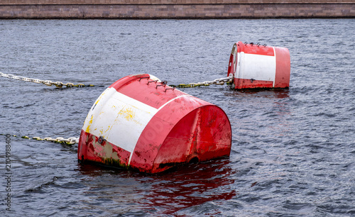 Red mooring buoys on the water in the sea.