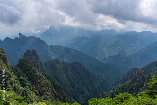 A panoramic view of the majestic green peaks and forested mountains at Sanqingshan Mountain in Jiangxi province of China under a cloudy sky