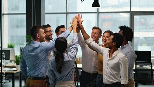 Team celebration in modern office colleagues high fiving after successful project completion