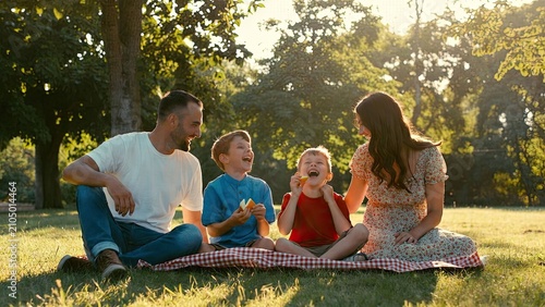 Joyful family picnic in a sunlit park cherishing moments of laughter and togetherness with children