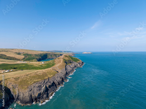 Fotografía Aerial views of a rugged coastal landscape with cliffs and turquoise sea in Wale