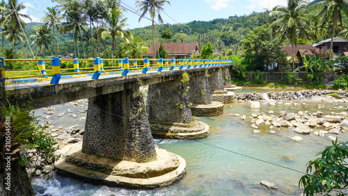 Φωτογραφία A scenic landscape featuring a sturdy concrete bridge spanning a rocky river in the rural region of Trenggalek, East Java, Indonesia
