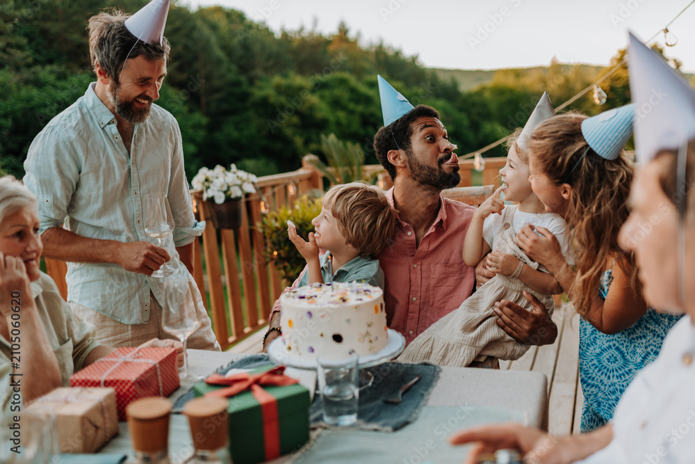 Naklejka premium Multi generation family celebrating birthday on terrace.