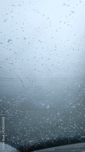 Car wiper clearing snow from a glass window The Concept of winter safety