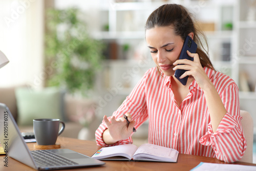 Quadro su tela Disgusted teleworker checking calendar talking on phone