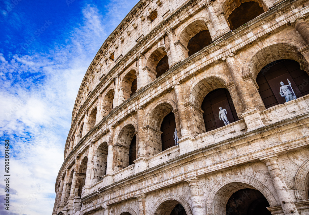 Obraz premium Colosseum arches and sculptures under blue sky, Rome