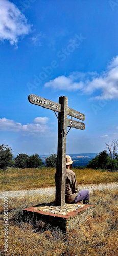 Walker Resting Beside Ancient Signpost on Bignor Hill Along the South Downs Way, West Sussex.