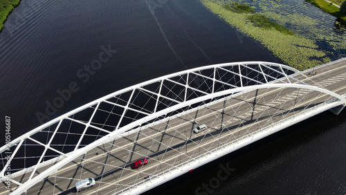 Foto Modern Parnu Raama bridge connecting urban landscapes over a river filled with g