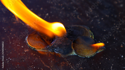 Obraz na plátně Euro cent coins burning intensely on a dark wooden surface, illustrating concept