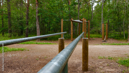 Obraz na plátne Outdoor gym space with parallel bars, pull up bars, and various wooden training