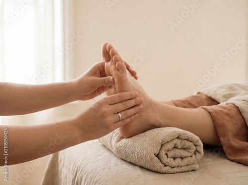 Professional foot massage in a spa. Therapist performing reflexology on a client's feet.