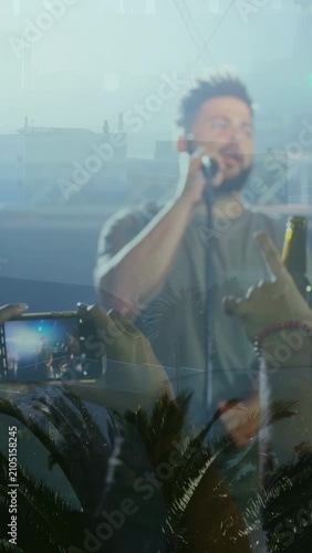 Vertical video: Music fan raising phone filming while singer singing into mic, crowd raising hands