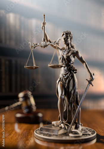 Legal Concept: Themis is the goddess of justice and the judge's gavel hammer as a symbol of law and order on the background of books
