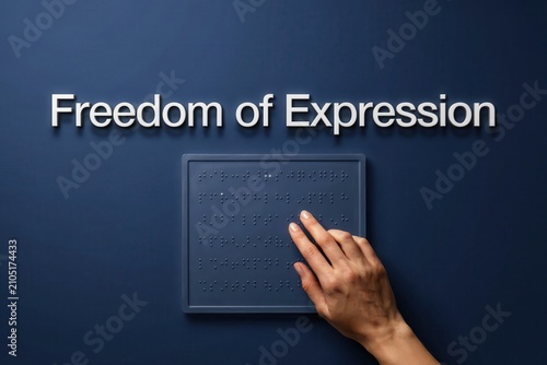 Hand reading braille message on dark blue background symbolizing freedom of expression and accessibility for blind people