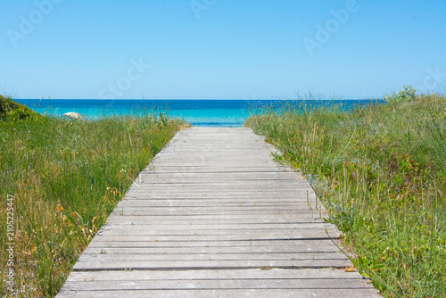 Wooden boardwalk leading to tranquil turquoise ocean beach