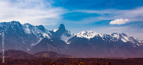 The banner Majestic Snow Capped Mountain Range Panorama Under Bright Blue Sky background