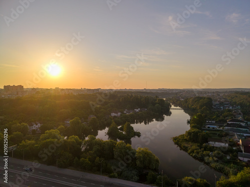 фотографія High angle drone viewpoint captures the green landscape of Vinnytsia with the calm Southern Bug river under a bright morning sunrise at dawn