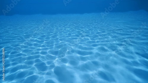 Underwater Light Refraction Patterns Rippling On Blue Pool Bottom