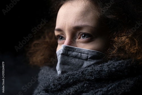 Woman wearing face mask reflecting on climate change