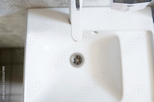 Modern white ceramic bathroom sink with a faucet viewed directly from above in a top-down aerial perspective