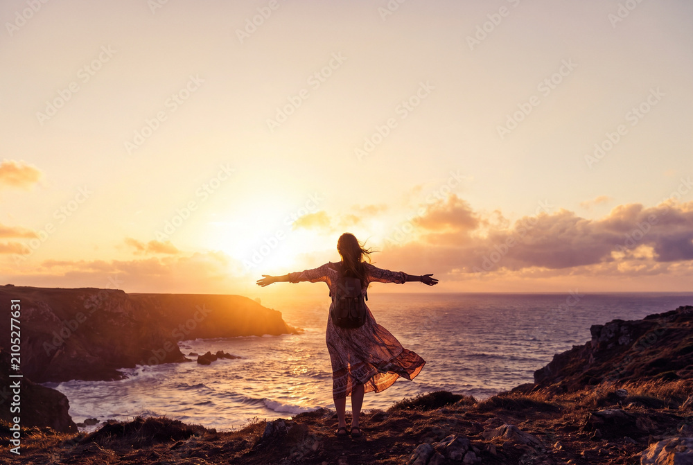 Fototapeta premium Woman Enjoying Freedom and Ocean View During Golden Hour